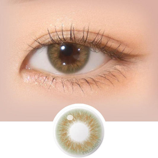 Close-up shot of model's eye adorned with Gemhour Hestia Olive daily color contact lenses with prescription, complemented by clean eye makeup, showing the brightening and enlarging effect of the circle contact lens on dark brown eyes, above a cutout of the contact lens pattern with limbal ring on a white background.
